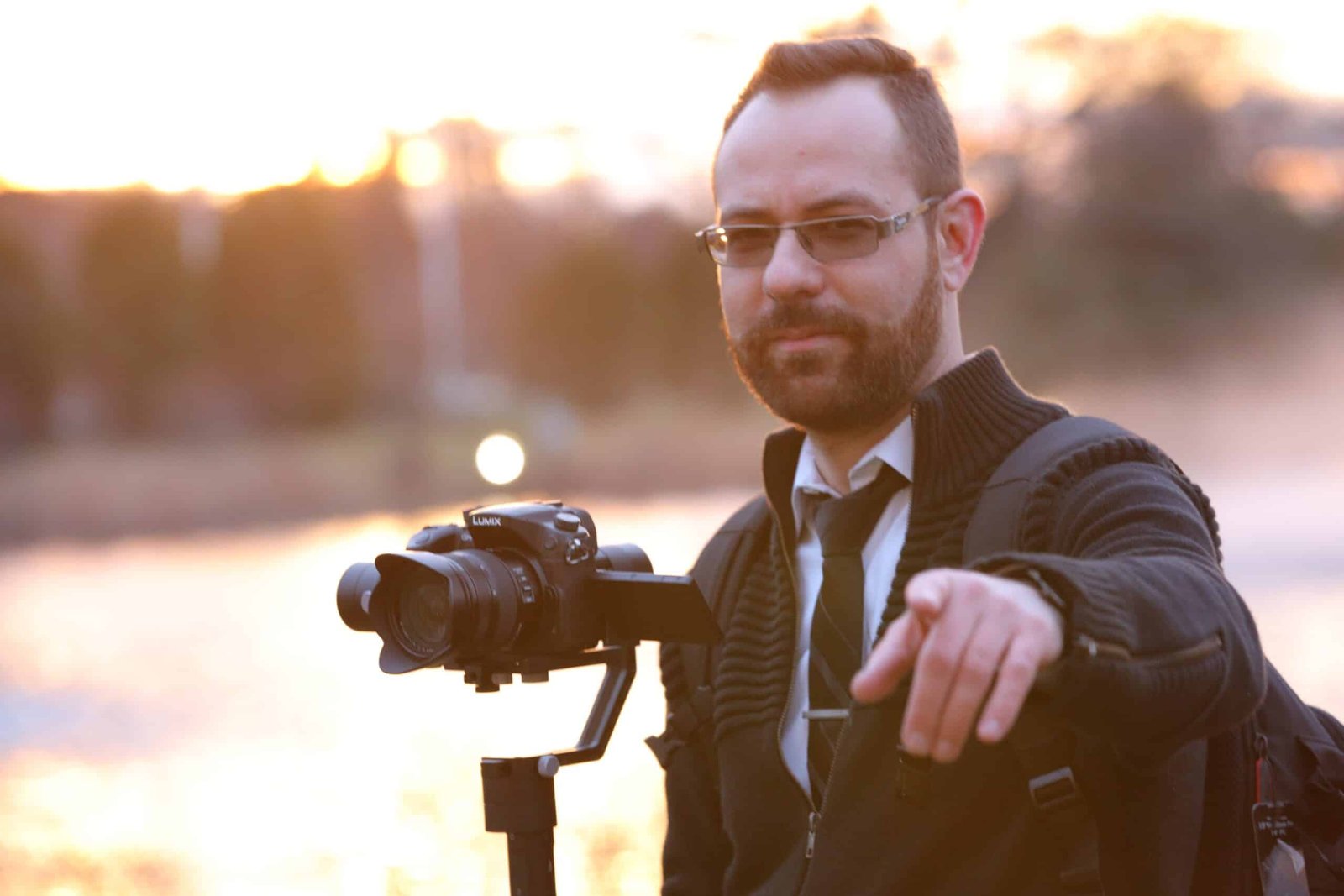 Videographer pointing at camera holding gimbal setup for event video production services.